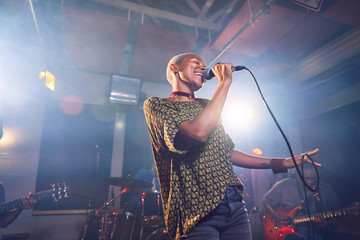 Female musician singing into microphone in recording studio