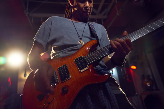 Male musician playing electric guitar on stage
