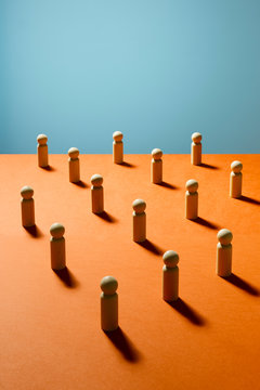 Wooden pawn chess pieces on orange surface