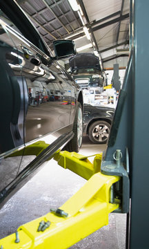 Car on hydraulic lift in auto repair shop