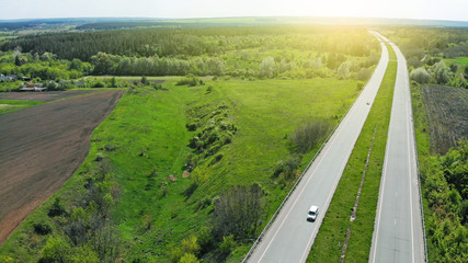 Aerial. Two-lane road between agricultural fields. View above from drone.