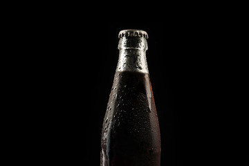 The neck of a foggy cold drink bottle on a black background with a copy space