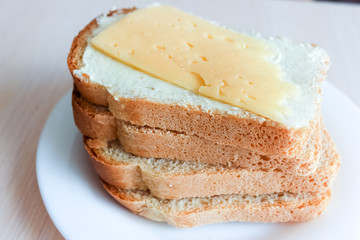 Stack of sandwich bread slices with butter and cheese