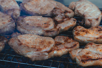 to cook meat on the coals on the grate of the grill