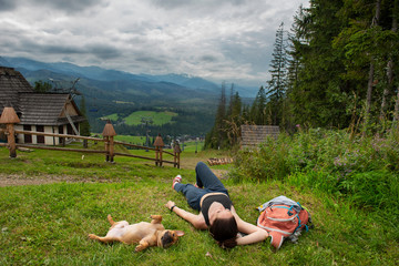 French Bulldog resting on the grass and looking at the Tatra Mountains. Travel after quarantine