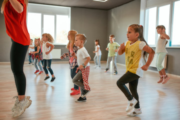 Studying modern dance. Group of little boys and girls dancing while having choreography class in...