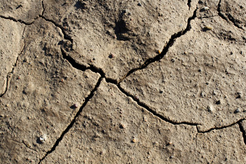 Fototapeta premium Drought cracke ground earth on top view, beautiful background full flame pattern crack surface texture, photo for graphic creative design background on hot arid climate weather, brown broken ground