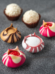 close up view to colored chocolate candies on the gray background in diagonal rows