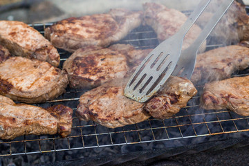 to cook meat on the coals on the grate of the grill
