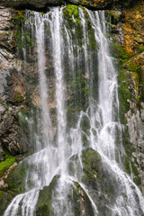 A mountain waterfall. A strong stream of water dropping down among rocks