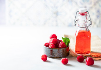 Homemade raspberry vinegar and fresh raspberries.