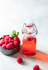 Homemade raspberry vinegar and fresh raspberries.