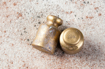 Fototapeta na wymiar Two antique bronze weights for scales on concrete background.