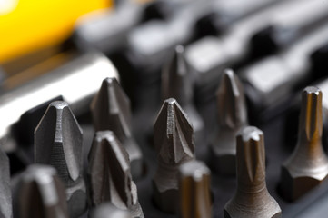 interchangeable screwdriver bits in a plastic box close-up macro isolated on a white background