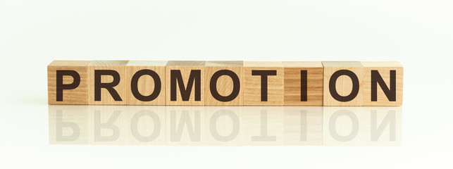 Promotion - word from wooden blocks with letters, promotion code, top view on white background