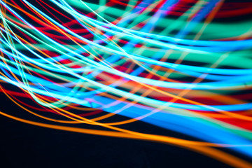 Colorful abstract photo of light streaks in fast motion against a black background 