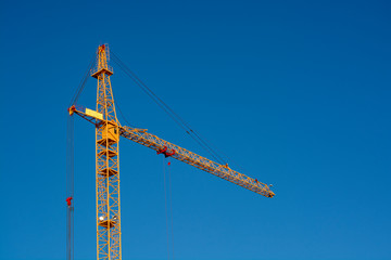 Crane. Construction crane. Huge crane against blue sky. Self-erection cranr. Tower crane.