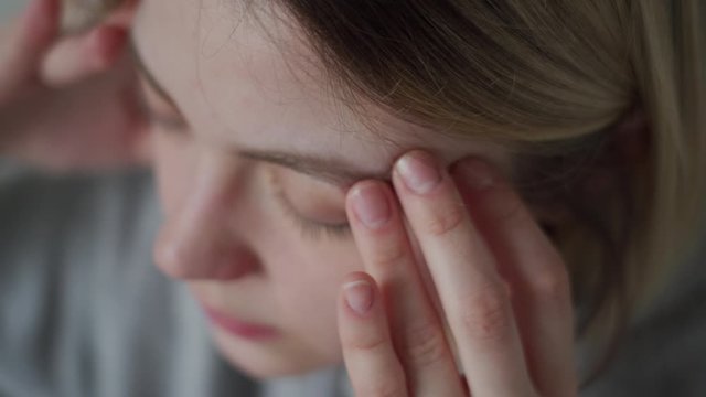 Massage with fingers. The girl has a migraine, headache, malaise.