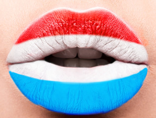 Female lips close up with a picture flag of Luxembourg. Blue, white, red