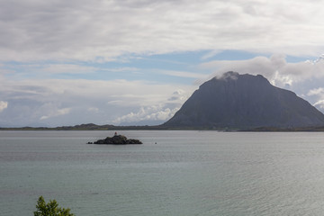 A mystical fjord in Norway with mountains and fog hanging over the water in polar day. midnight...