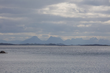 Norwegian fjord and mountains surrounded by clouds, ideal fjord reflection in clear water. selective focus.