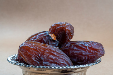 Ramadan concept for muslim fasting break: Macro of few natural dried organic sweet date fruits in a...