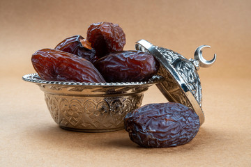 Religious iftar Ramadan concept: Side view of few dried organic sweet date fruits in a silver...