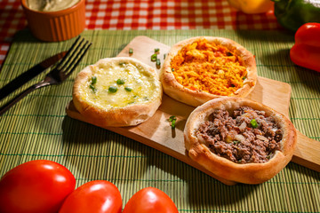 3 sabores de esfihas em mesa de restaurante