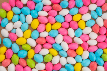 Fototapeta na wymiar Top view of flat layed almond candies for special events. Colorful sweet confections for textured background and copy space