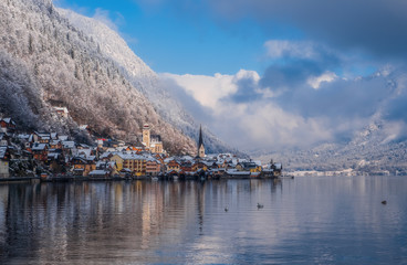 Image of cold and snowy winter in Austria. Beautiful mountain and nature at Hallstatt near Obertraun city opposite the Hallstatter See lake at foggy weather. January 2020