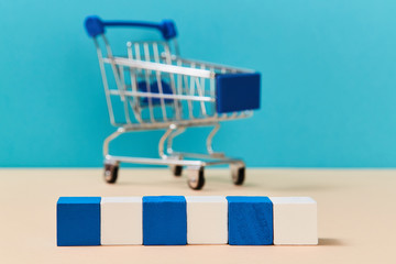 Wooden cubes in line for creative design or inscription. Template with shopping cart on blurred...