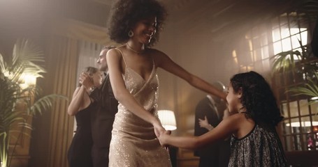 Mother and daughter having fun at a party. Woman dancing with her cute girl at party.
