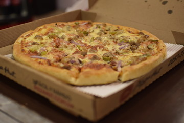 Man taking out a slice of ham pizza from his freshly baked mold.