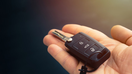 car remote control key in hand with black background
