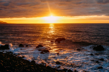 Obraz premium Sunset over the ocean on a tropical island. Sunny evening on Tenerife Background color with gradient and grain, sound effect.