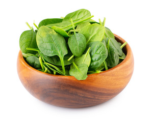 Spinach leafs in wooden bowl isolated on white background