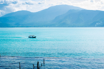 Boat with tourists crossing the lake of Coatepeque in El Salvador, Central America