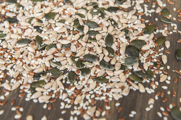 Seed of flax, sunflower, pumpkin, sesame seeds on a wooden background. Top view. Photo taken with selective focus.