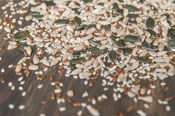 Seed of flax, sunflower, pumpkin, sesame seeds on a wooden background. Top view. Photo taken with selective focus.