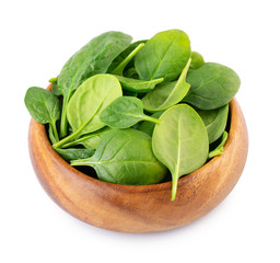Spinach leafs in wooden bowl isolated on white background