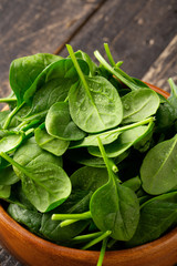 Close-up view of Spinach leafs in Wooden Bowl on wooden background