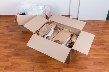 Moving boxes with packing material for fragile items on the floor