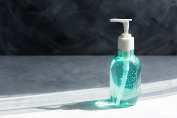 For antiseptic treatment of hands in a period of coronavirus. A bottle of gel on a gray background. Hand disinfection and treatment with the product. Clear blue antiseptic gel.