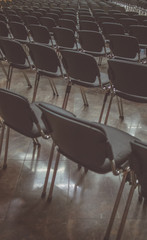 Vintage photo of modern seats in a conference hall. Multitude of chairs on a lecture or a meeting