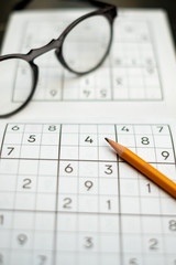 Empty sudoku puzzle with a pencil and glasses