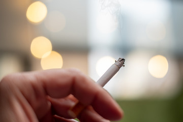 Close up of a hand handling a cigarret with smoke
