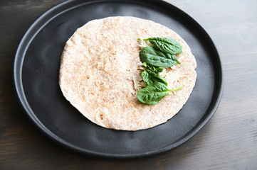 Whole tortilla with spinach and shredded chicken.