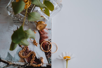 jewelry on a white background next to a flower delicious perfume