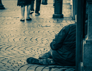People giving zero interest in a poor person sitting or begging on the street. Concept of miserable...