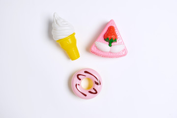 Fototapeta na wymiar Collection of food toys for kids. Ice cream, slice of cake, donuts. Flay lay image. White background